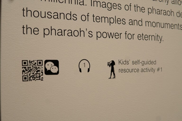 NGV's Pharaoh Exhibition depicting ancient relics from egypt. This photo shows a patron observing the didactic on the wall.