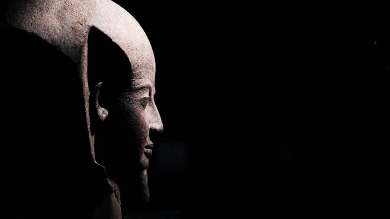 NGV's Pharaoh Exhibition depicting ancient relics from egypt. This photo shows a patron observing the didactic on the wall.